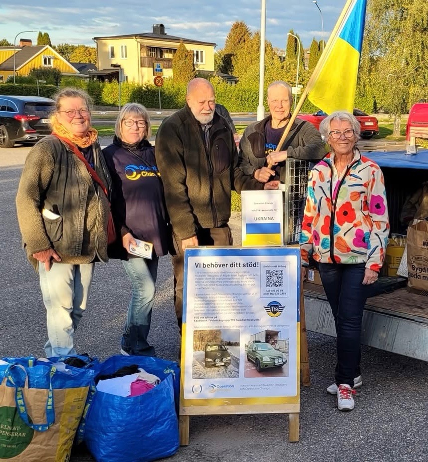 T19-volontärer med insamlade gåvor och Ukrainas flagga
